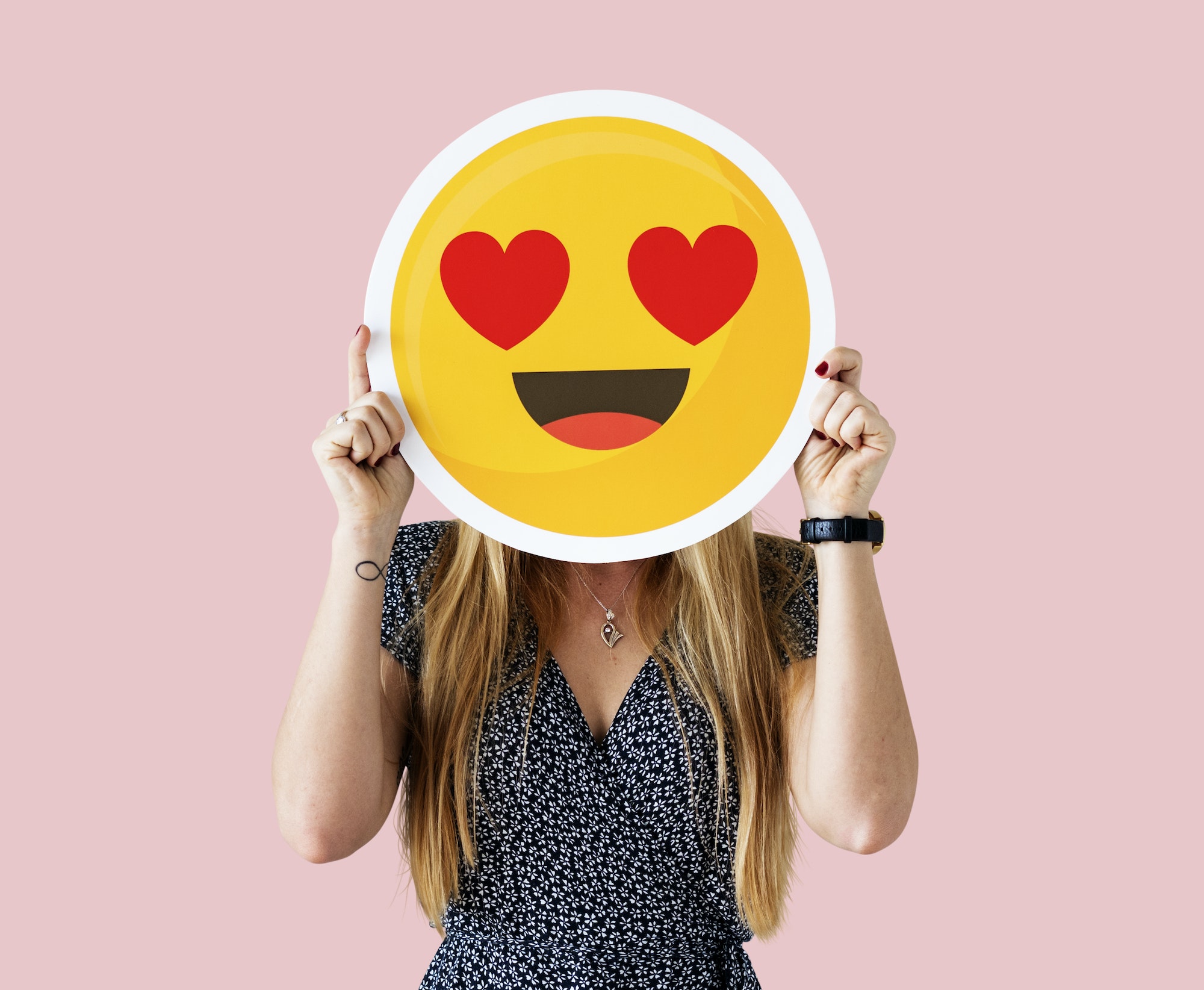 Cheerful woman holding emoticon icon